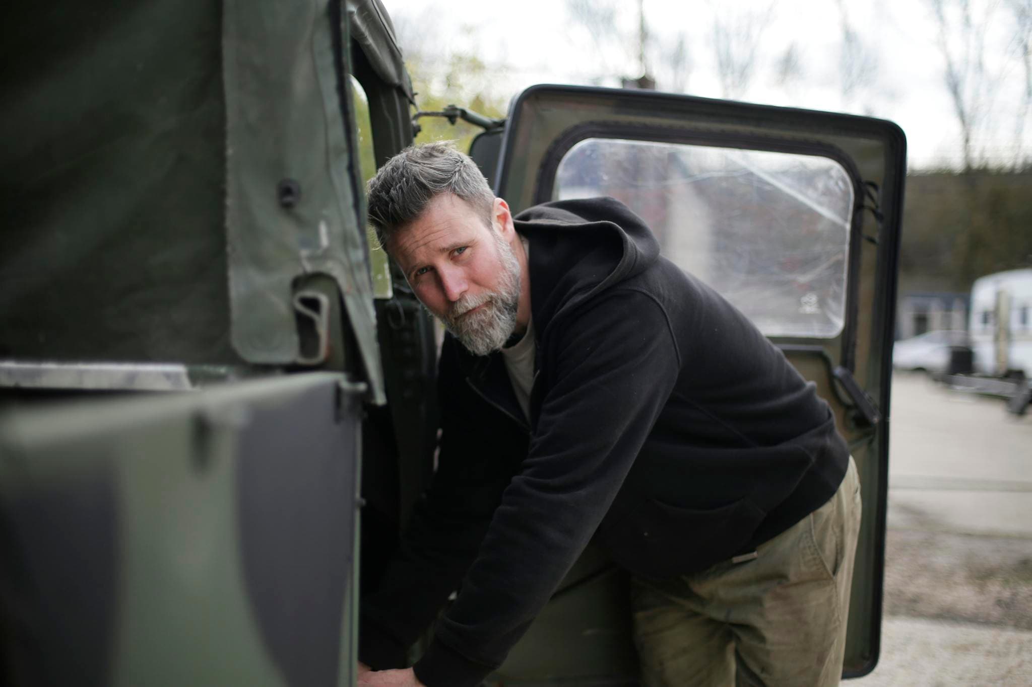 A focused mechanic with a beard works on a garage door